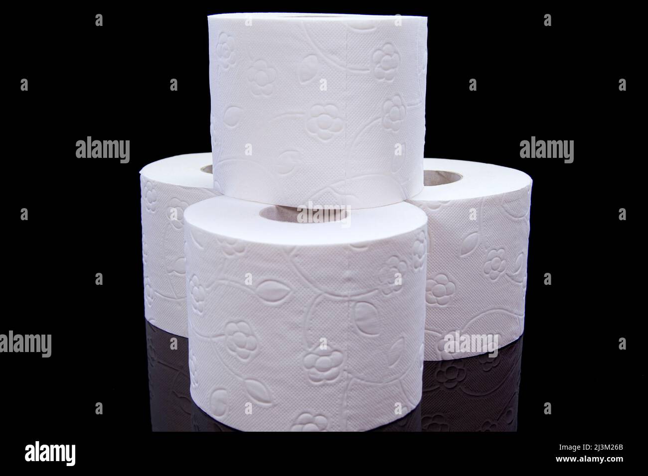 Toilet paper rolls on a black background. Presentation of toilet paper roll, isolated on black background. Stock Photo