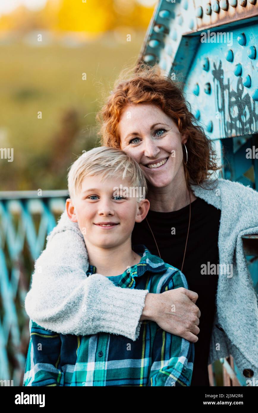 Outdoor portrait of a mother and son standing on a bridge at a park; Edmonton, Alberta, Canada Stock Photo
