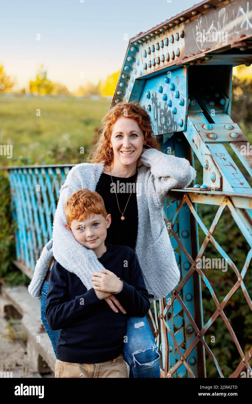 Outdoor portrait of a mother and son standing on a bridge at a park; Edmonton, Alberta, Canada Stock Photo