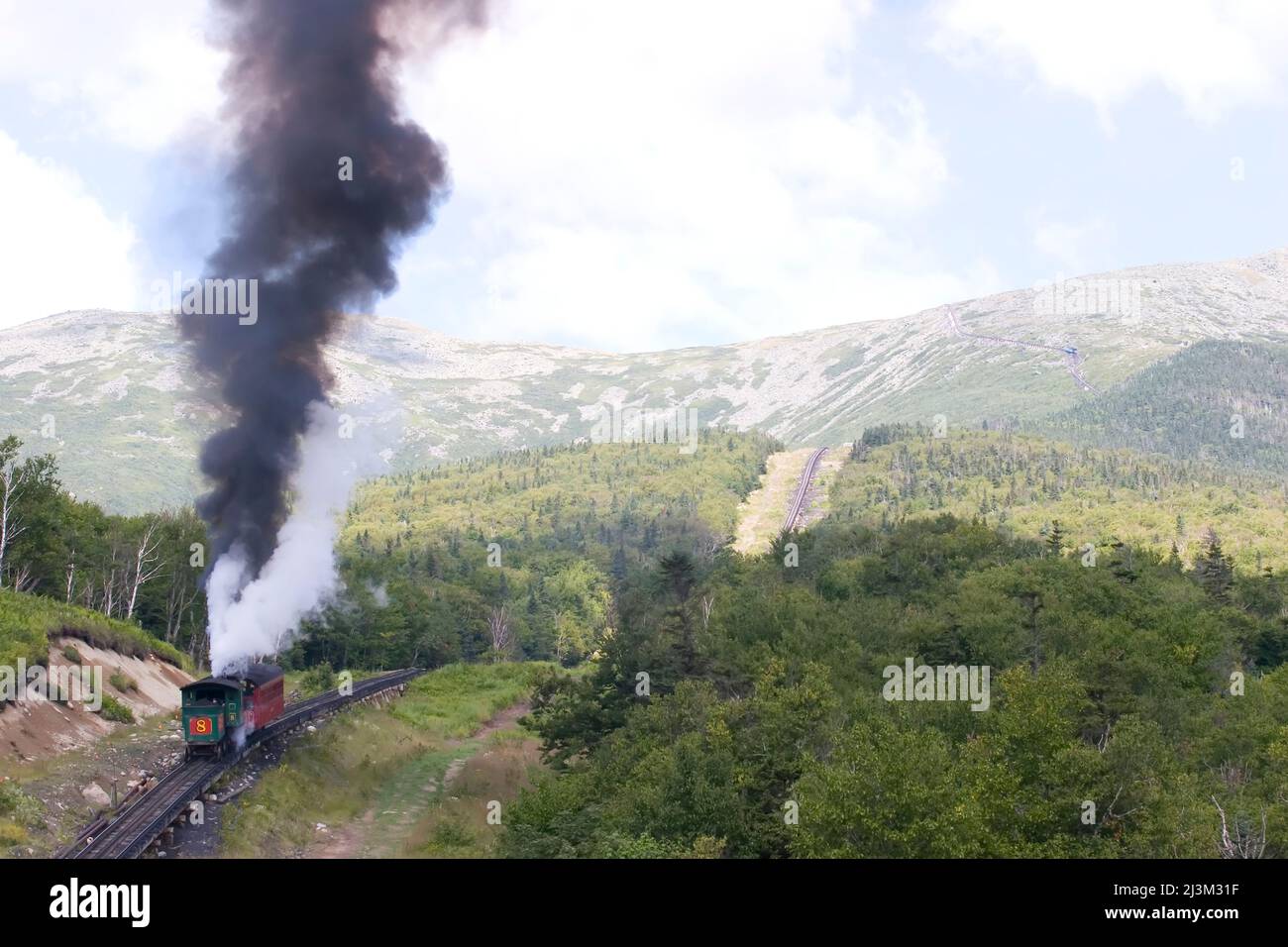 Smoke rises from the steam engine of the cog railway.; Mount Washington, New Hampshire. Stock Photo