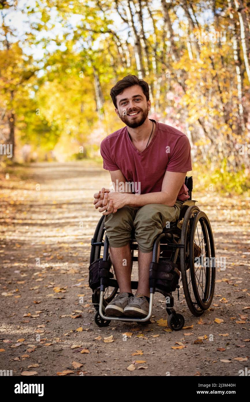 Portrait of a paraplegic man in a wheelchair outdoors in a park in autumn; Edmonton, Alberta
