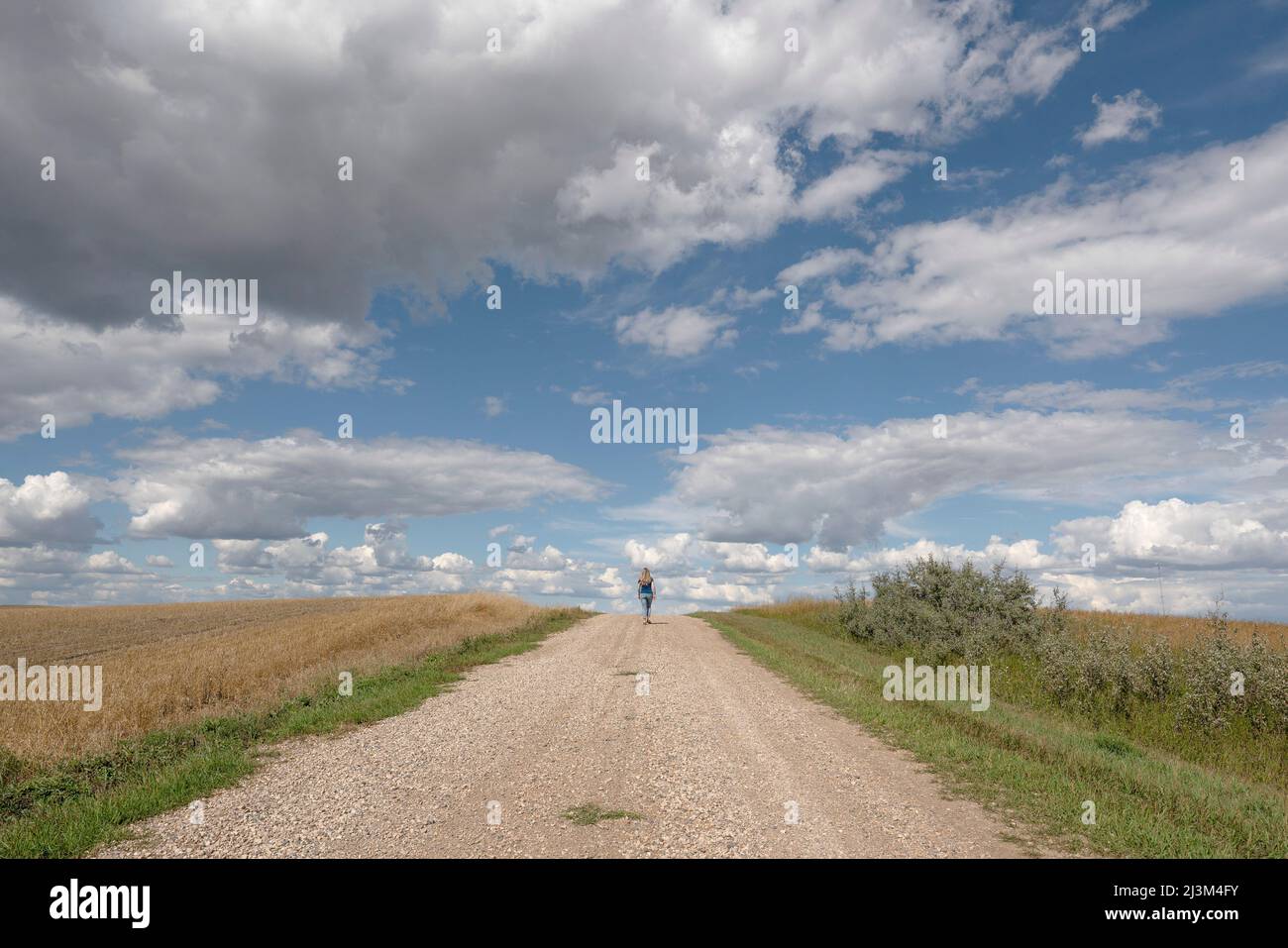 Woman walking away country road hi-res stock photography and images - Alamy