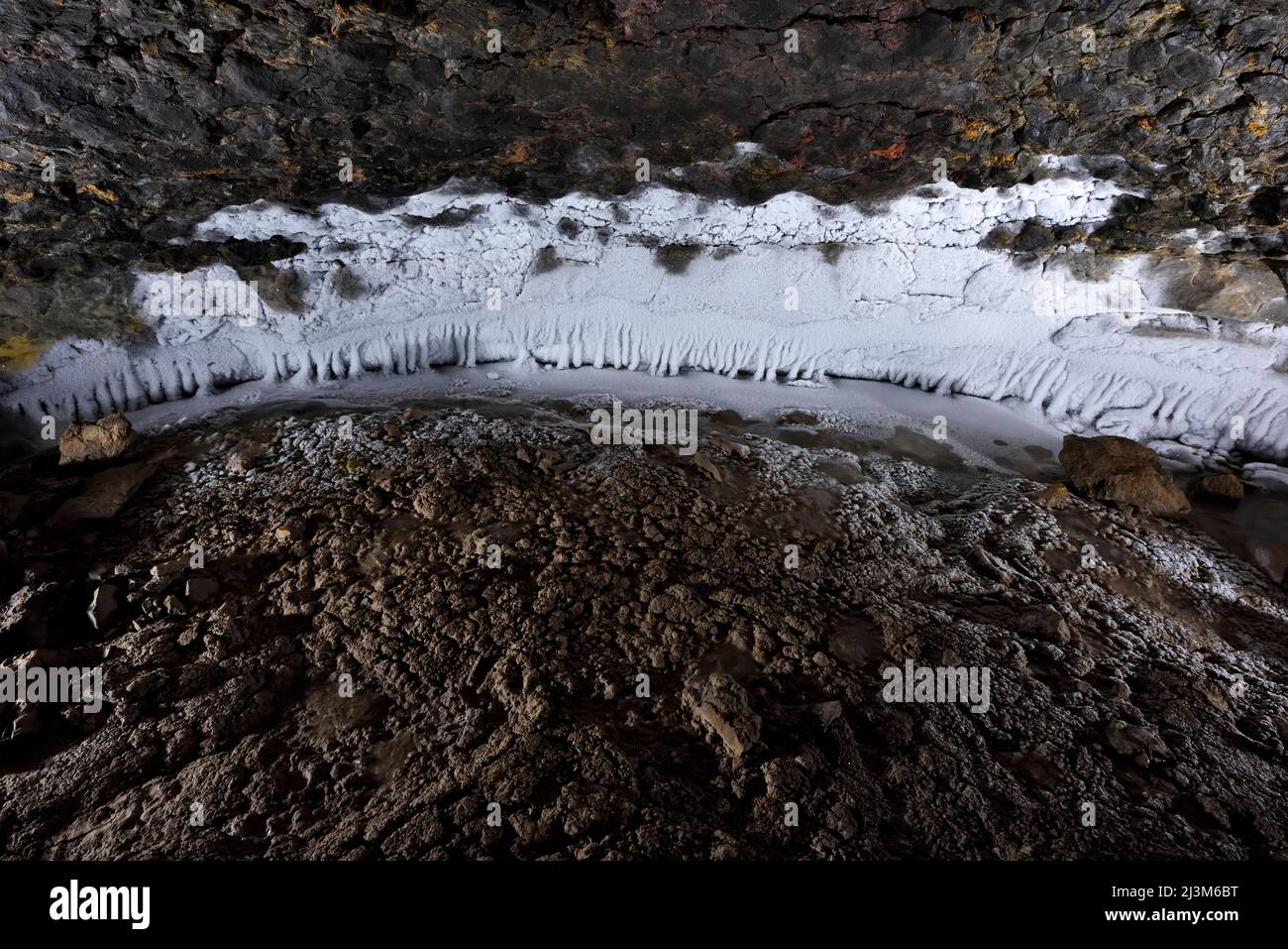Ice clings to the wall and floor of The U-Shaped Cave.; Greenland. Stock Photo