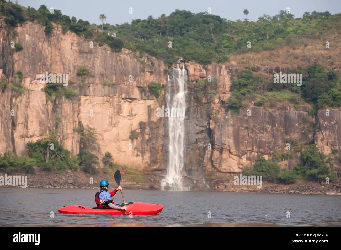 A kayaker paddles towards a large waterfall on the Congo river.; Congo ...