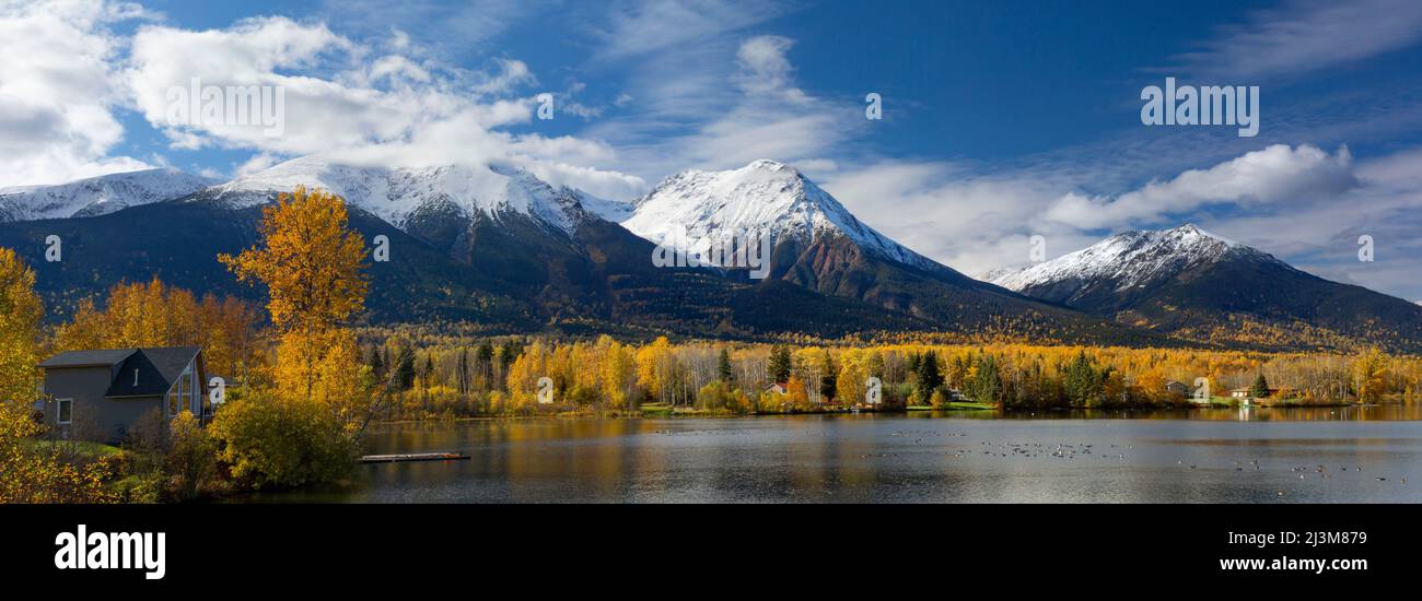 Tranquil Lake Kathlyn surrounded by autumn coloured trees and snow-capped Coast Mountains, viewed from Lakedrop Inn, Watson's Landing, BC, Canada Stock Photo