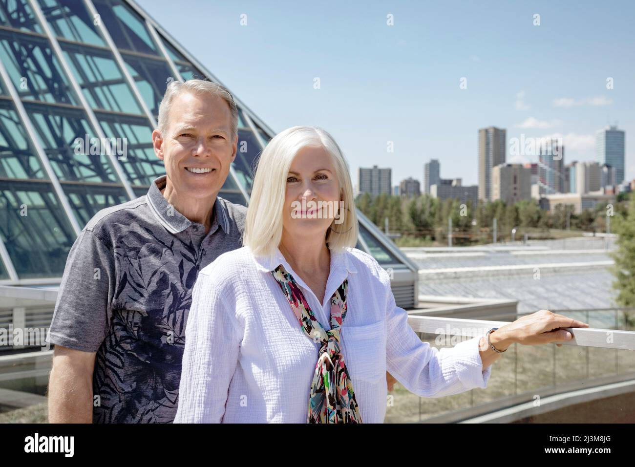 Outdoor portrait of a mature couple with a city skyline and architecture in the urban background; Edmonton, Alberta, Canada Stock Photo