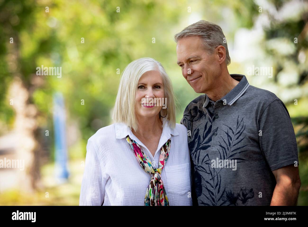 Outdoor portrait of a mature couple in a park, the husband looking at the wife; Edmonton, Alberta, Canada Stock Photo