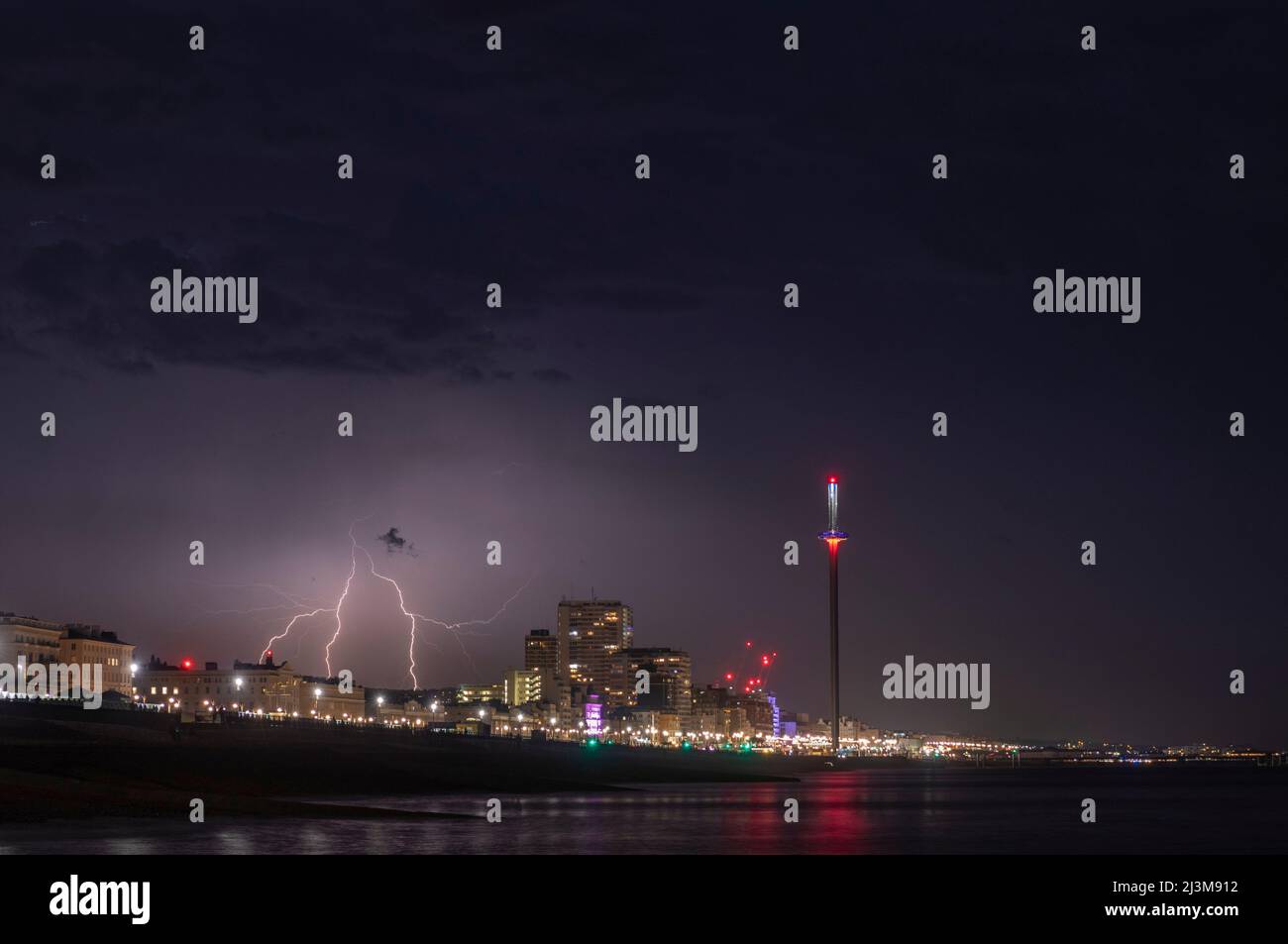 A dramatic bolt of lightning strikes behind the city of Brighton on a stormy summer's night on the south coast of the UK Stock Photo