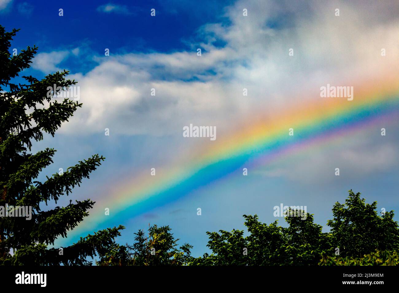 Blue sky with clouds and rainbow hi-res stock photography and images ...
