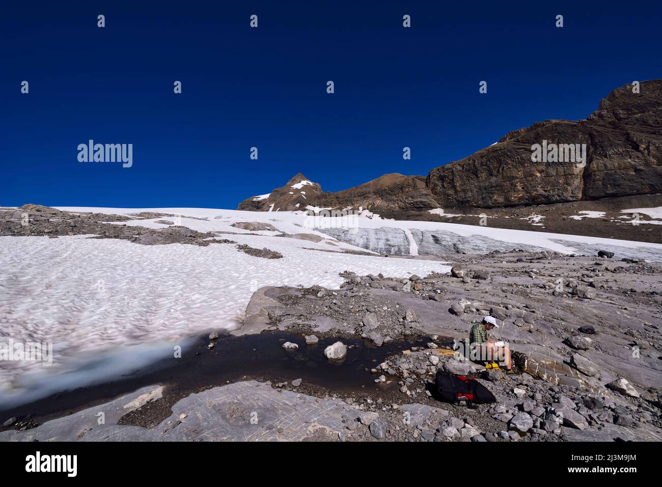 A scientist collects a water sample from a surface stream that sinks ...