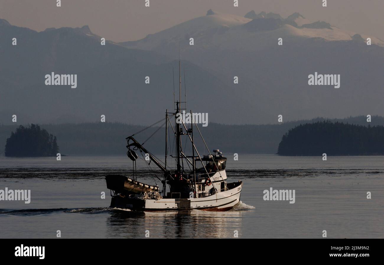 A commercial fishing boat loaded with nets departs in calm waters through  Frederick Sound in Southeast Alaska Stock Photo - Alamy