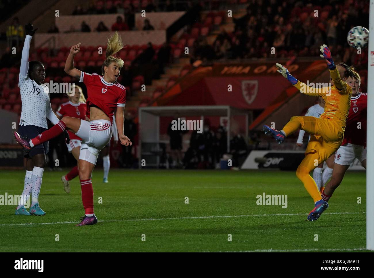 Parc y Scarlets, Llanelli, Wales. 8 Apr 2022. #3 Gemma Evans (Wales) sends the ball past goalkeeper Pauline Peyraud-Magnin (France) from an offside position. Credit: Penallta Photographics/Alamy Live News Stock Photo