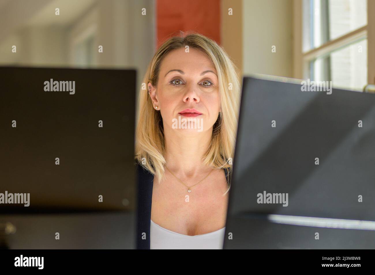 Close up of a confident businesswoman or manageress looking at the camera with a thoughtful expression Stock Photo