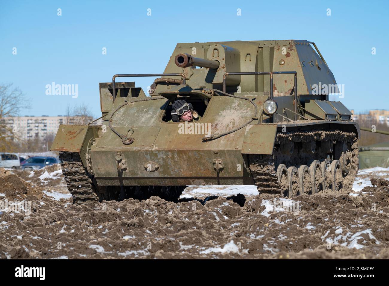 KRASNOE SELO, RUSSIA - MARCH 27, 2022: A driver looks out of the hatch of the old soviet self-propelled artillery mount SU-76 on a sunny spring day Stock Photo