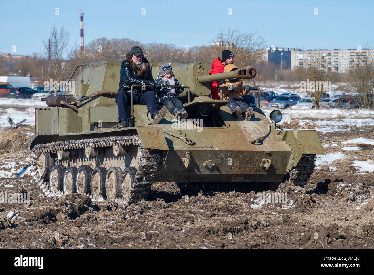 RED VILLAGE, RUSSIA - MARCH 27, 2022: Visitors to the military-patriotic park 'Steel landing' ride on the old self-propelled artillery mount of SU-76 Stock Photo