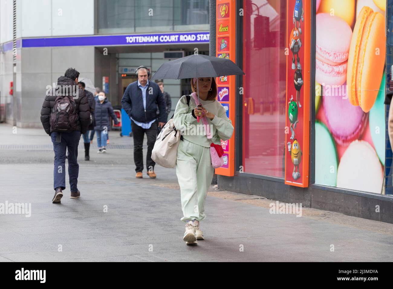 Weather is seen to be relatively dry this morning in London with occasional drizzles as morning commuters pass by Tottenham Court Road and Oxford Circ Stock Photo