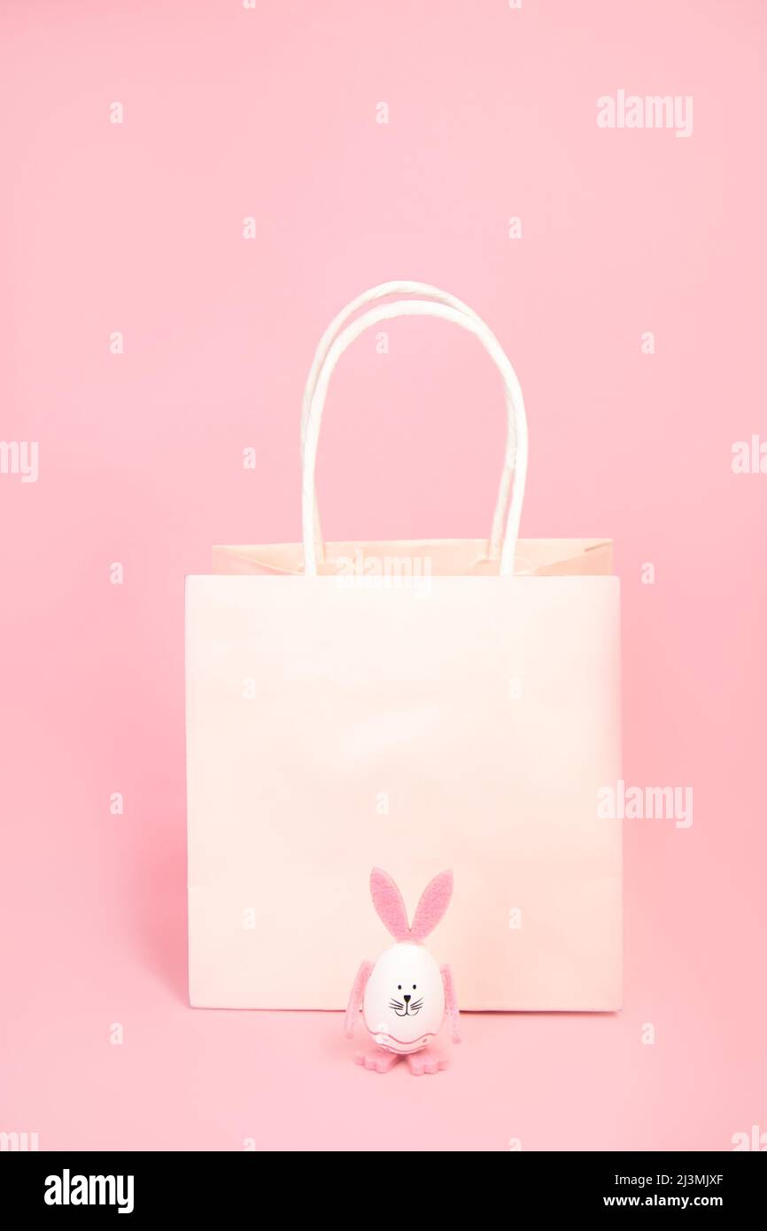 Paper, pink bag and a hare with pink ears and paws on a pink background. Stock Photo