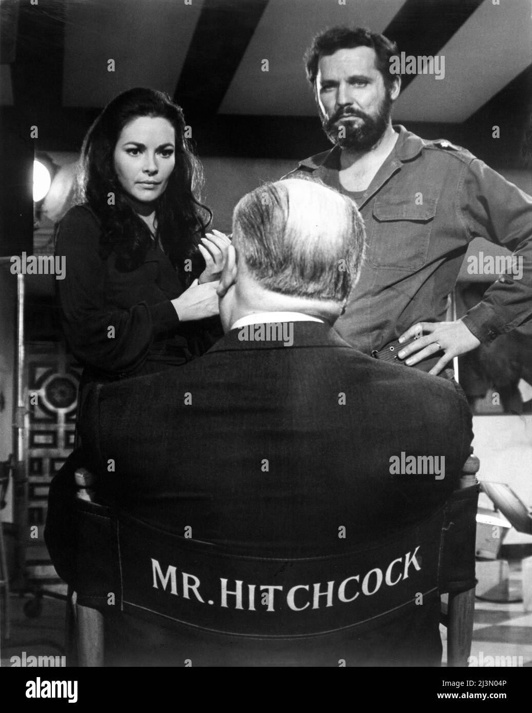 ALFRED HITCHCOCK on set candid with KARIN DOR and JOHN VERNON during filming of TOPAZ 1969 director ALFRED HITCHCOCK novel Leon Uris screenplay Samuel A. Taylor music Maurice Jarre costume design Edith Head Alfred J. Hitchcock Productions / Universal Pictures Stock Photo