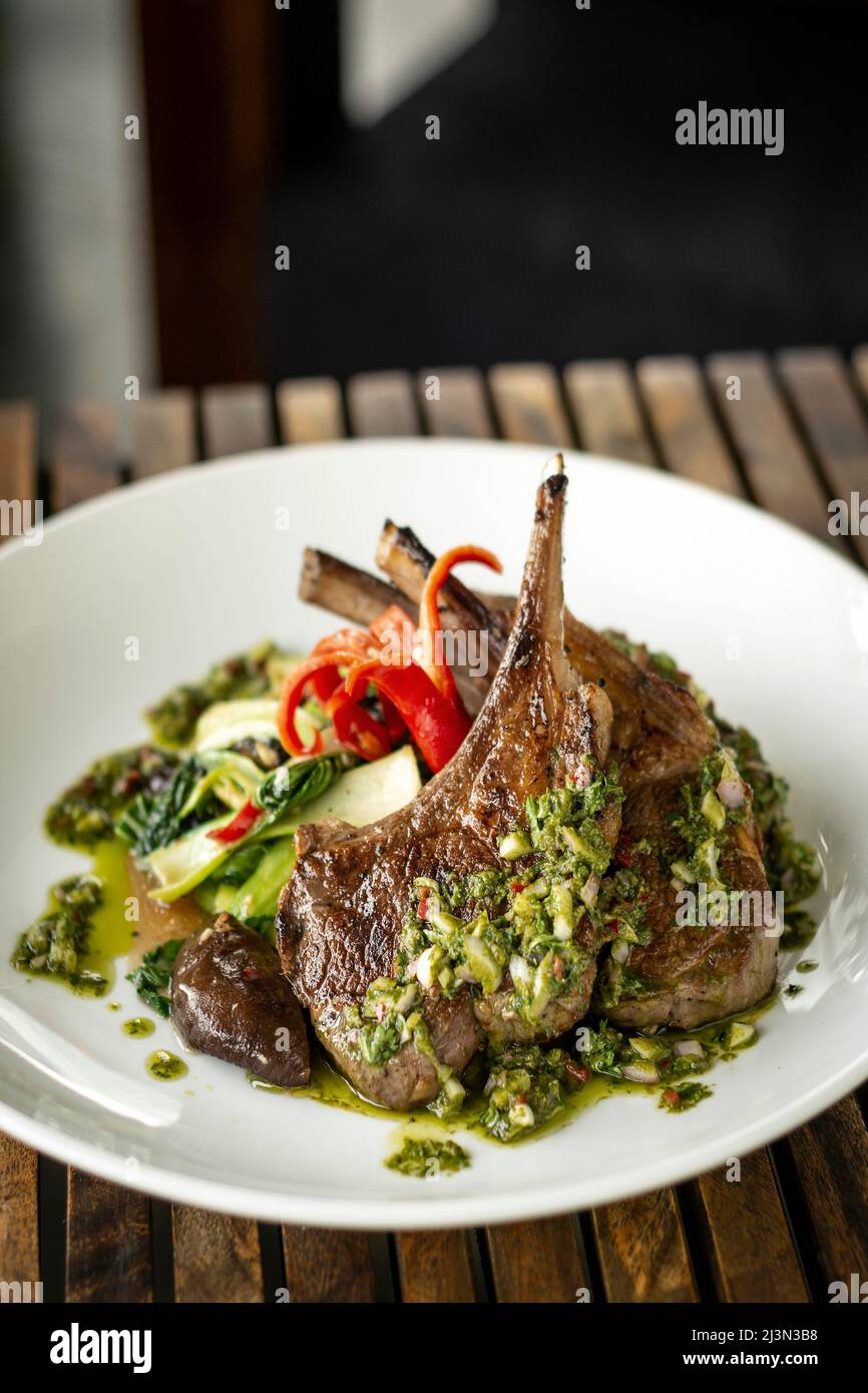 grilled organic lamb chops meal with traditional chimichurri sauce in argentina Stock Photo