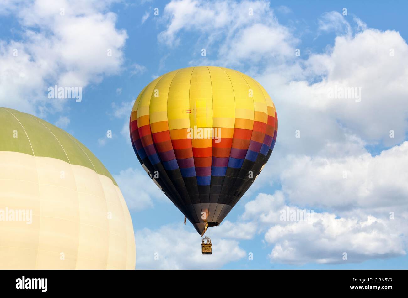 Colorful hot air balloon flying over blue sky Stock Photo - Alamy