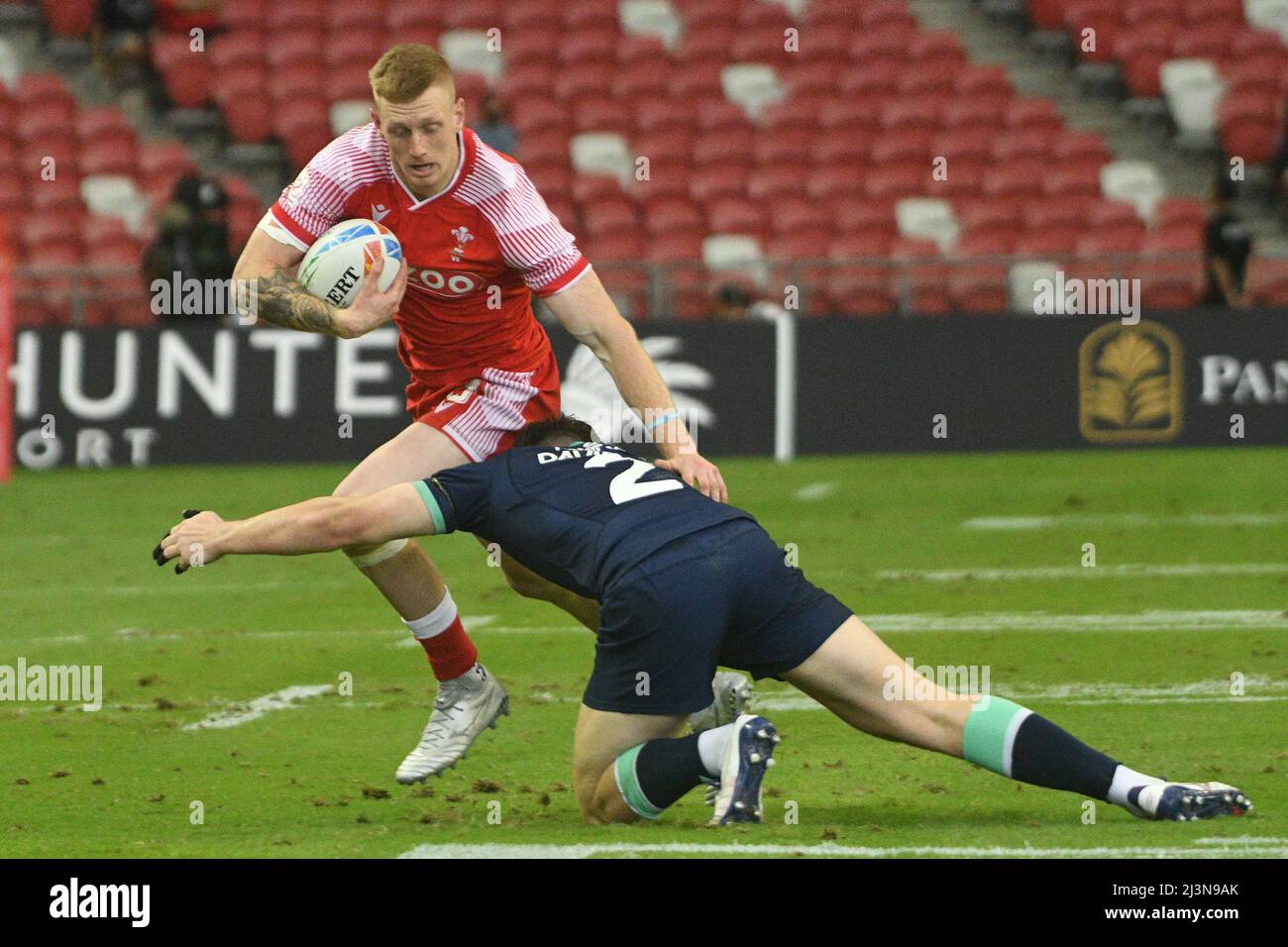 Singapore. 9th Apr, 2022. Cole Swannack (L) of Wales competes during the Pool C match between Scotland and Wales at the HSBC World Rugby Sevens Singapore stop, held in the National Stadium on April 9, 2022. Credit: Then Chih Wey/Xinhua/Alamy Live News Stock Photo