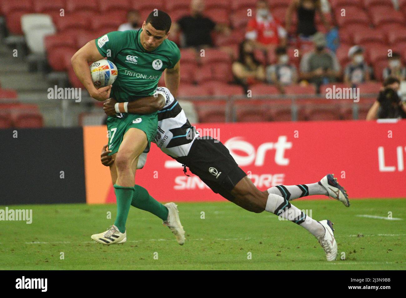 Singapore. 9th Apr, 2022. Jordan Conroy (L) of Ireland competes during the Pool D match between Ireland and Fiji at the HSBC World Rugby Sevens Singapore stop, held in the National Stadium on April 9, 2022. Credit: Then Chih Wey/Xinhua/Alamy Live News Stock Photo