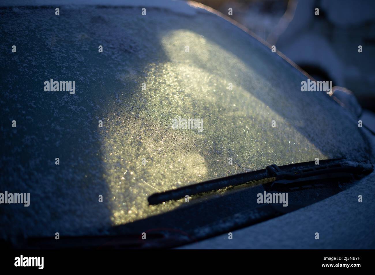 Frozen car window. Ice on windshield of transport. Parking in winter