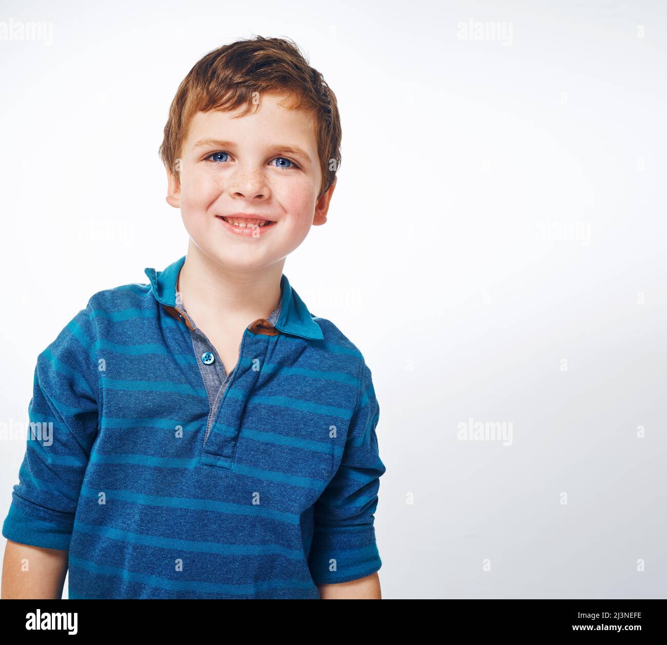 His smile is just adorable. Studio shot of a young kid against a grey background. Stock Photo