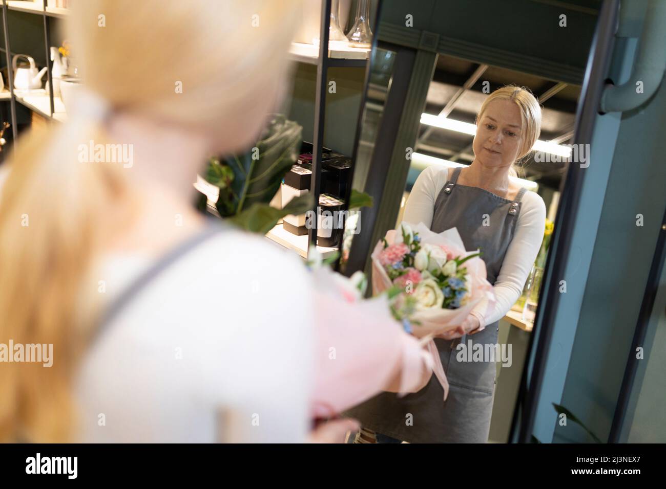 a flower shop worker examines a freshly picked bouquet of cut flowers