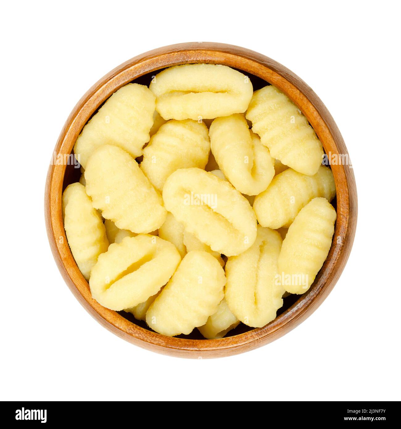 Raw gnocchi, Italian dumplings, in a wooden bowl. Made of small lumps of dough, with ridges in the size of a thumb. Composed of potato and wheat flour. Stock Photo