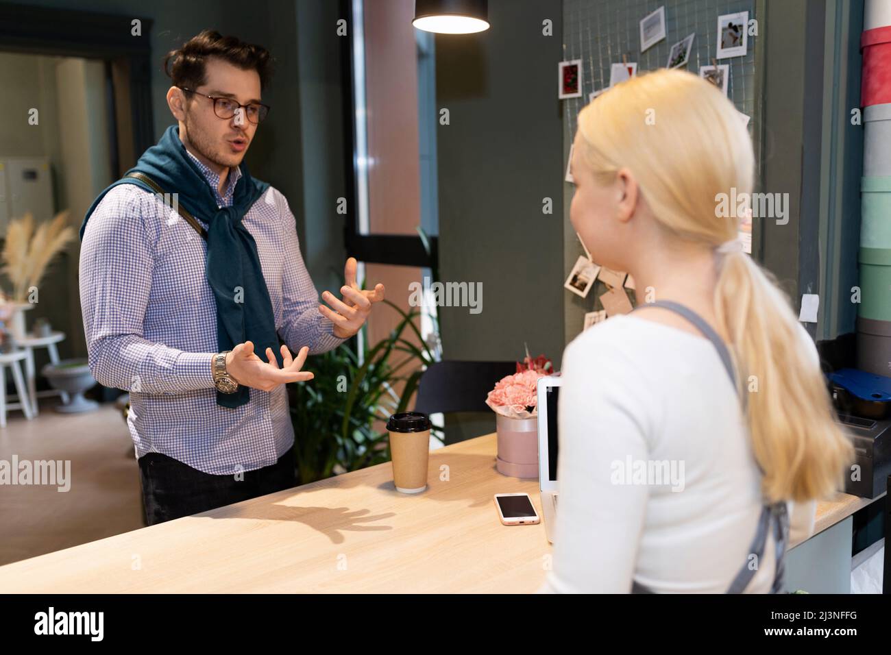 a customer in a flower shop explains to the florist what kind of