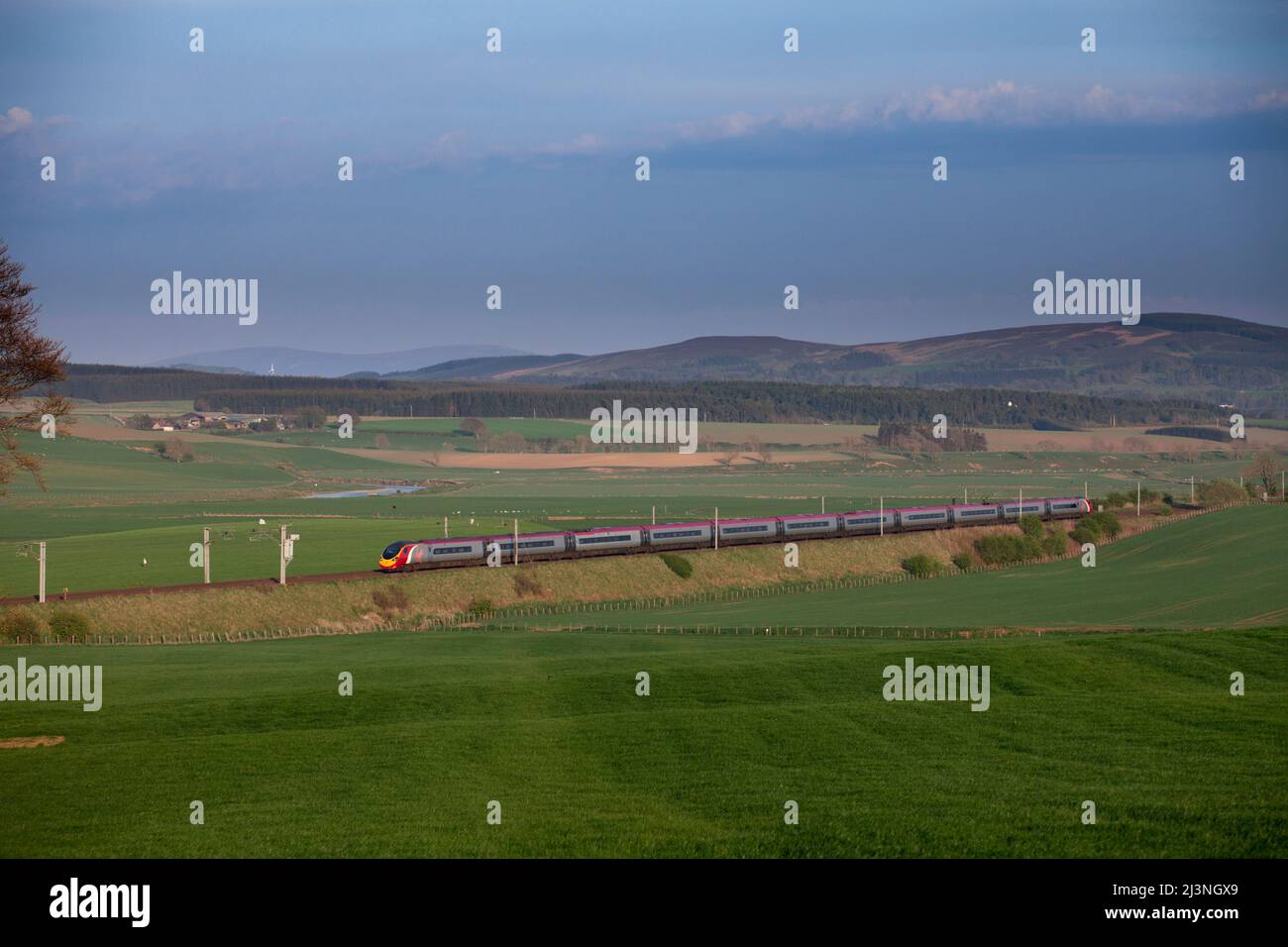 Virgin trains Alstom Pendolino train passing the countryside at Carstairs on the west coast mainline in Scotland Stock Photo