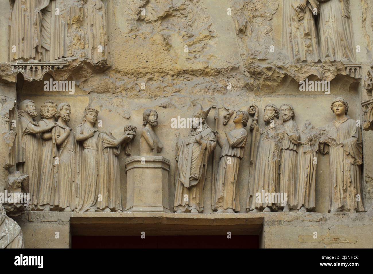 Baptism of King Clovis I by Saint Remigius of Reims depicted in the tympanum of the central portal of the north facade of the Reims Cathedral (Cathédrale Notre-Dame de Reims) in Reims, France. Stock Photo