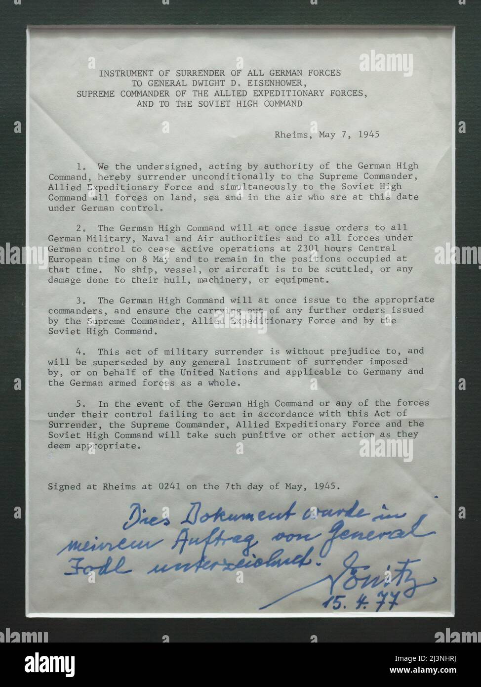 Text of the German Instrument of Surrender signed in Reims on 7 May 1945 with the handwritten confirmation of German admiral Karl Dönitz written on 15 April 1977 on display in the Museum of the Surrender (Musée de la Reddition) in Reims, France. The first German Instrument of Surrender that ended World War II in Europe was signed at 02:41 Central European Time (CET) on 7 May 1945 in the building which serves now as the museum. Admiral Karl Dönitz served as the President of Germany at the moment of the German Instrument of Surrender. The inscription in German means: This document was signed upo Stock Photo