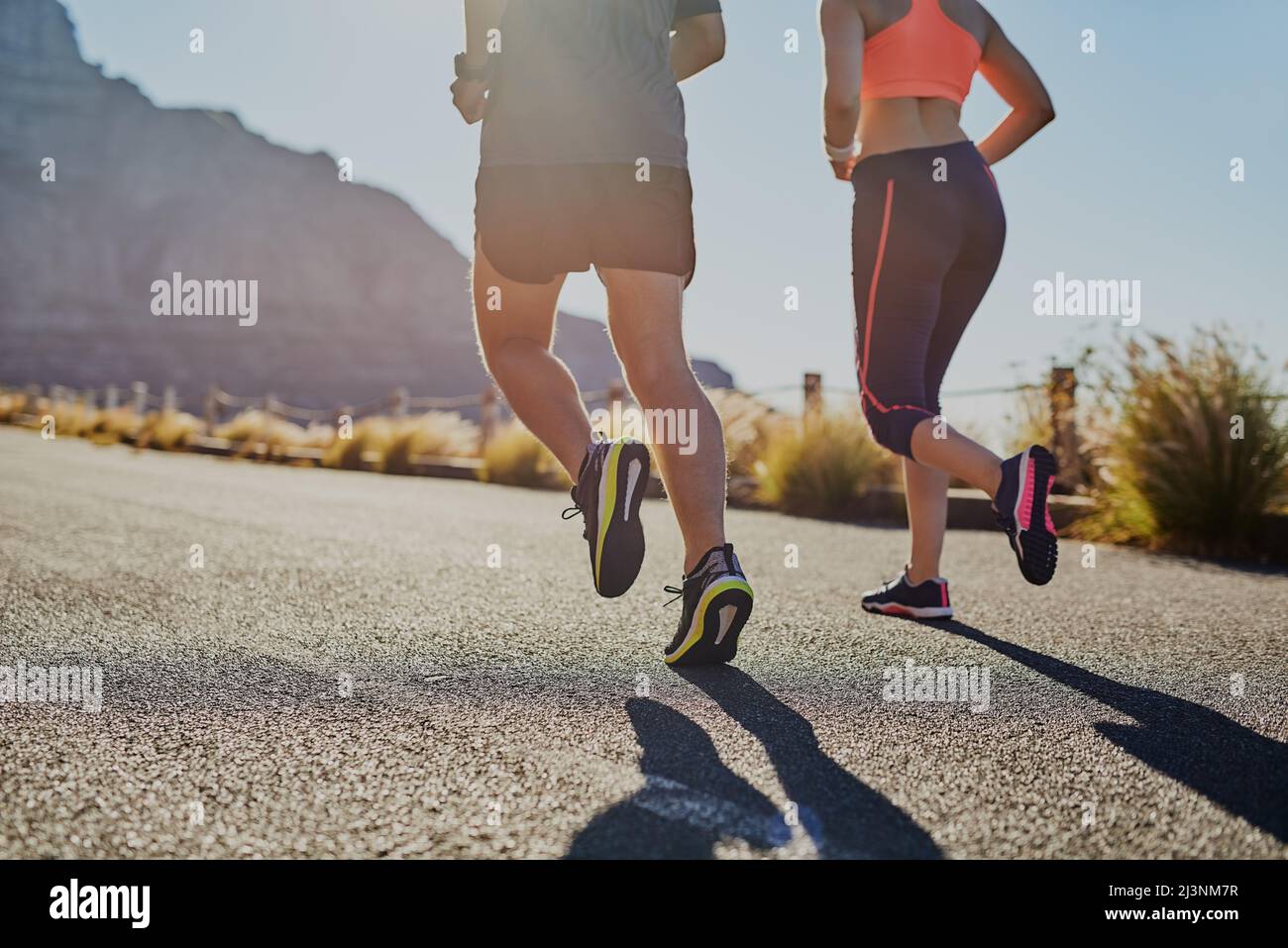 Working towards a better life. Rearview shot of two unrecognizable young people running on the road. Stock Photo
