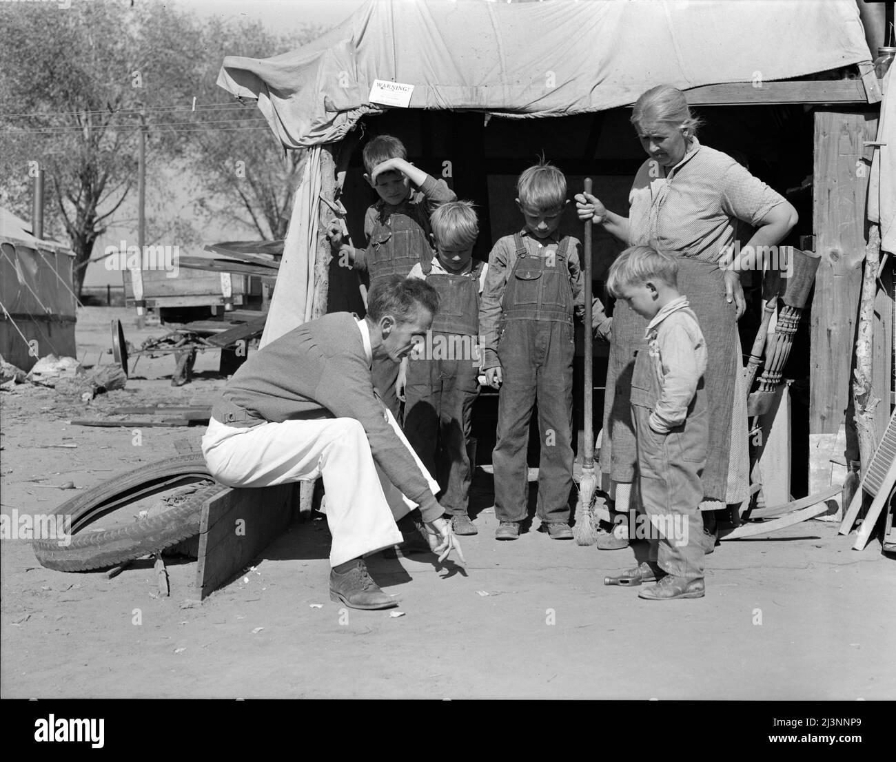 Tom Collins, manager of Kern migrant camp talking with drought refugee