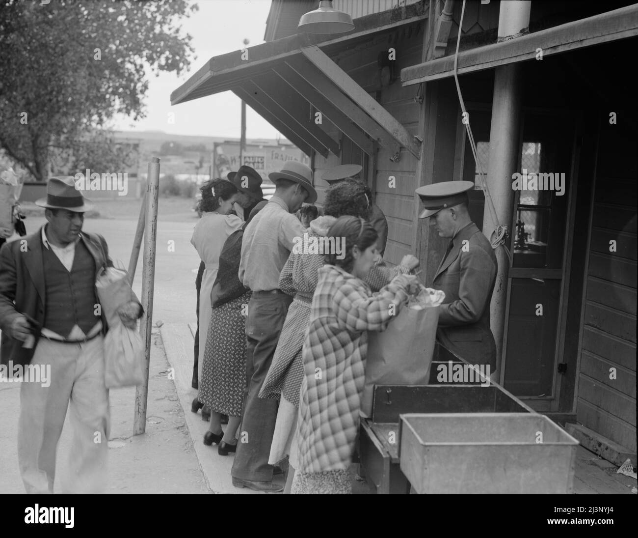 Plant quarantine inspectors examining packages brought over the bridge between Juarez, Mexico and El Paso, Texas. Families and housewives returning to their homes in El Paso after their Saturday marketing in Juarez, where they benefit by the present rate of exchange. Stock Photo