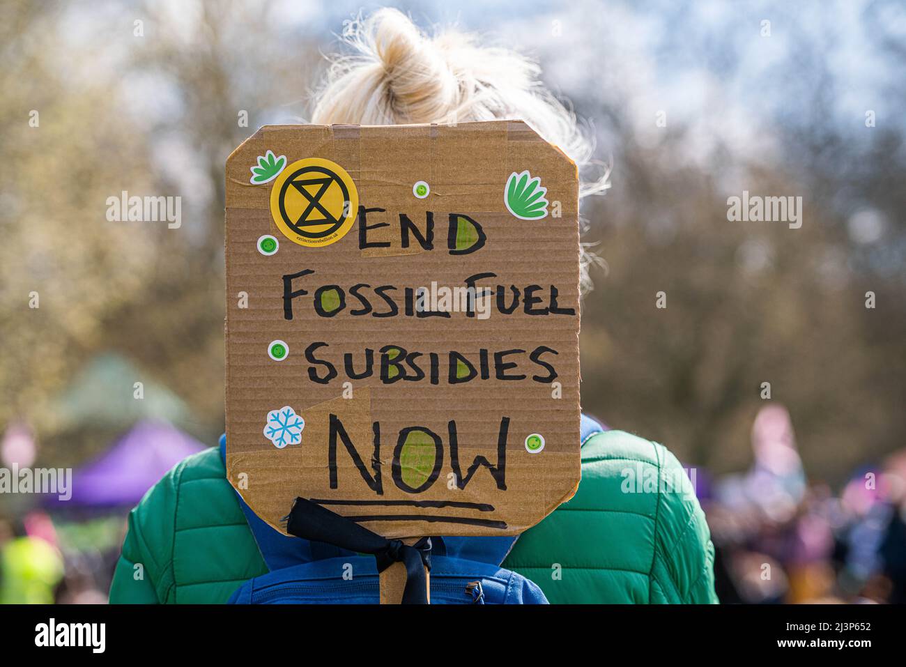 LONDON, UK. 9 April, 2022 .   A climate activist from Extinction Rebellion with a sign "End fossil fuel subsidies" in Hyde Park  before marching to central London to demand climate justice and  an end to the fossil fuel economy. Extinction Rebellion has vowed to bring  more disruptive protests  planned around Easter to London.  Credit: amer ghazzal/Alamy Live News Stock Photo