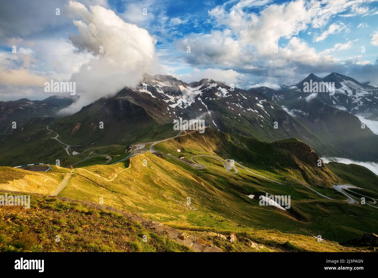 A great view of the green hills glowing by sunlight. Dramatic and picturesque morning scene. Location famous resort Grossglockner High Alpine Road, Au Stock Photo