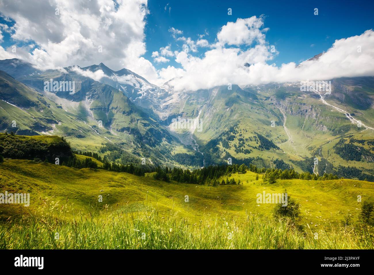 A great view of the green hills glowing by sunlight. Dramatic and picturesque morning scene. Location famous resort Grossglockner High Alpine Road, Au Stock Photo