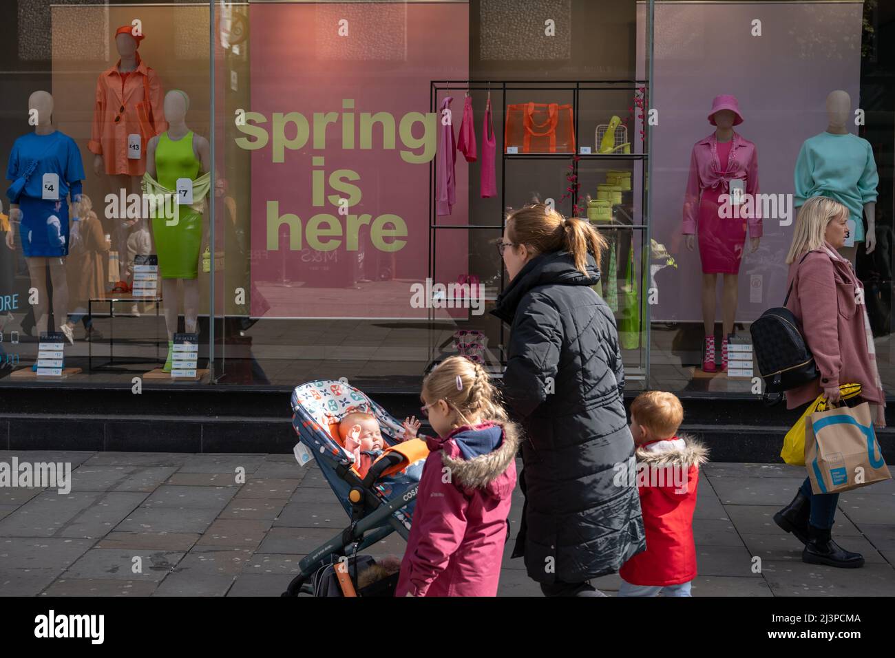 A family out shopping on Northumberland Street, Newcastle upon Tyne, UK, in Spring, pass window dressing. Stock Photo