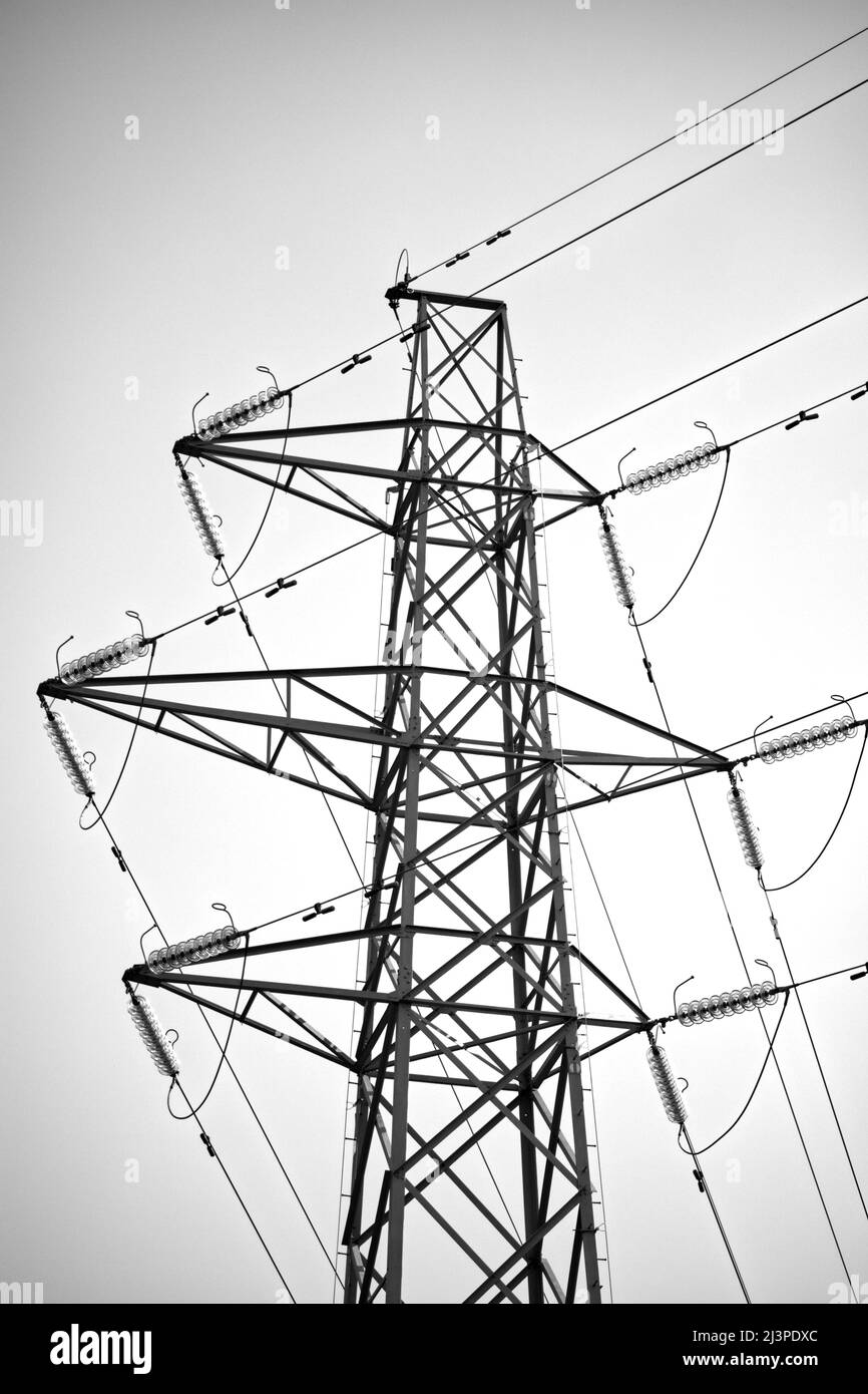 Power Generation and distribution, renewable wind turbines, overhead lines and pylons for energy transmission and distribution Stock Photo