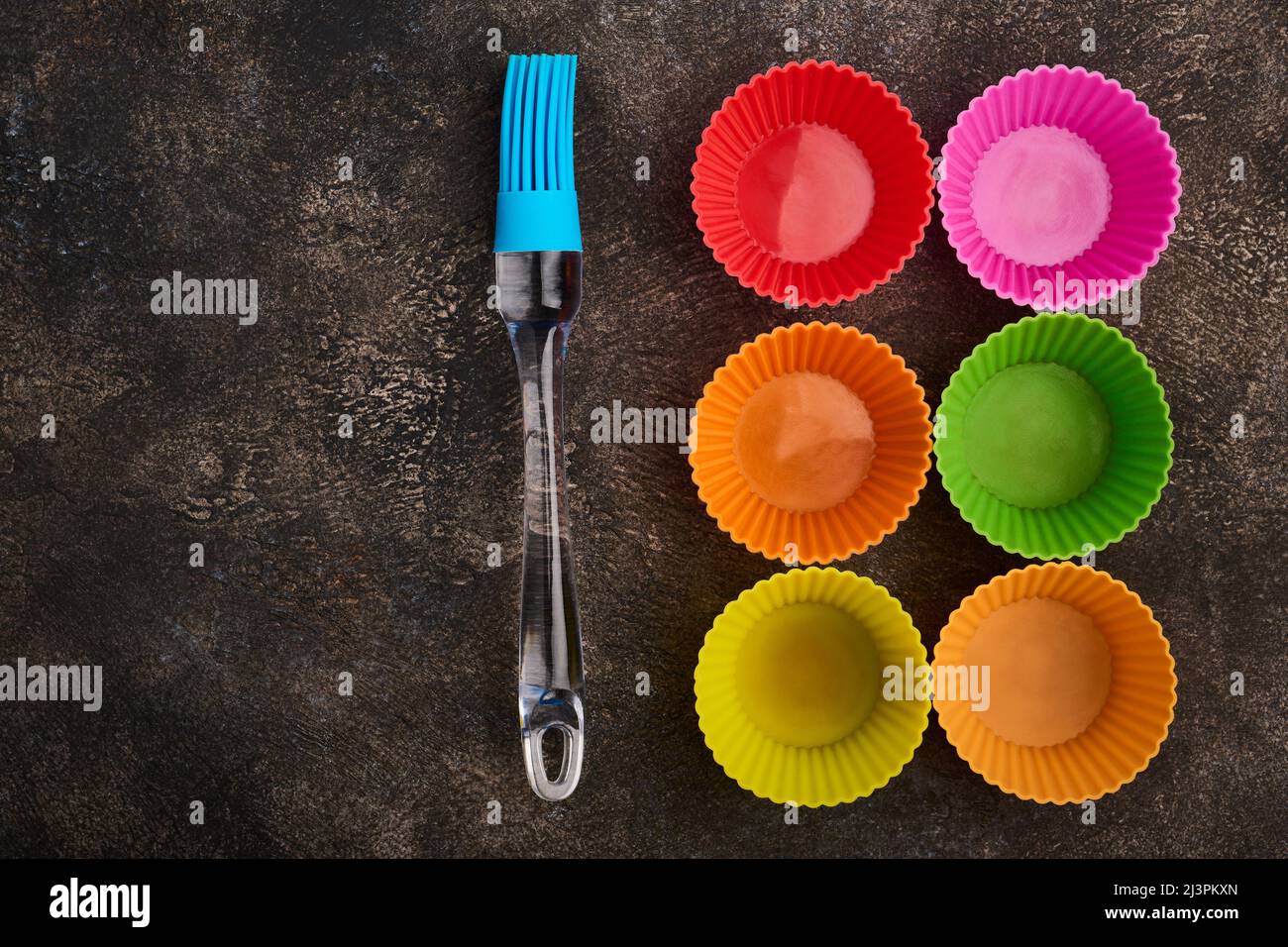 Cooking silicone brush and silicone cupcake molds, close up, on dark background Stock Photo