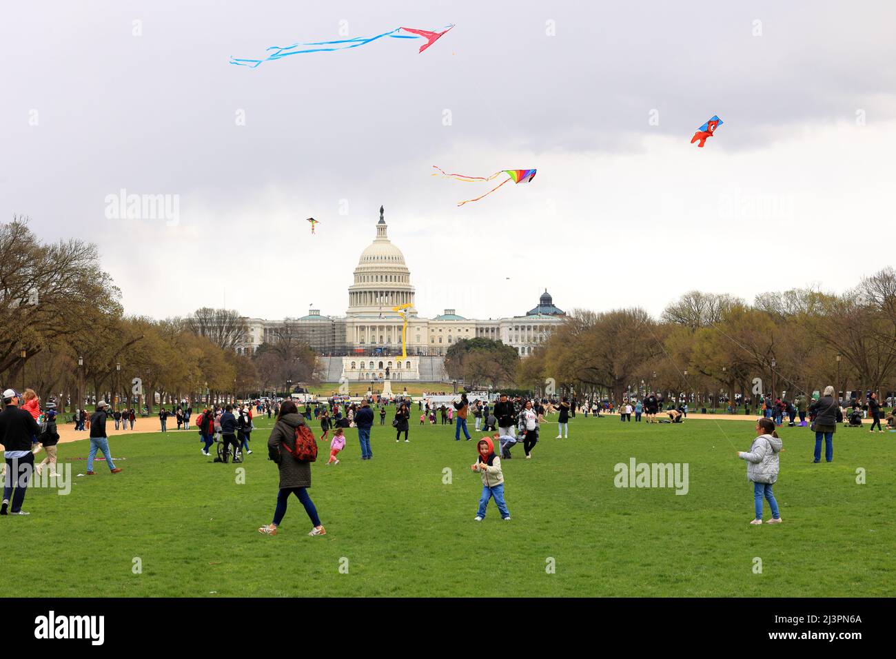 Kids, people flying kites on the National Mall with the US Capitol in the background during the Cherry Blossom festival, Washington DC, March 26, 2022 Stock Photo