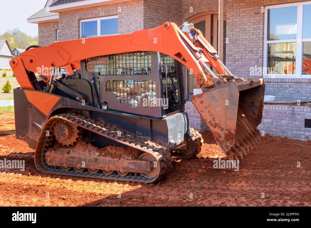 Mini bulldozer working with earth, moving soil doing landscaping Stock Photo