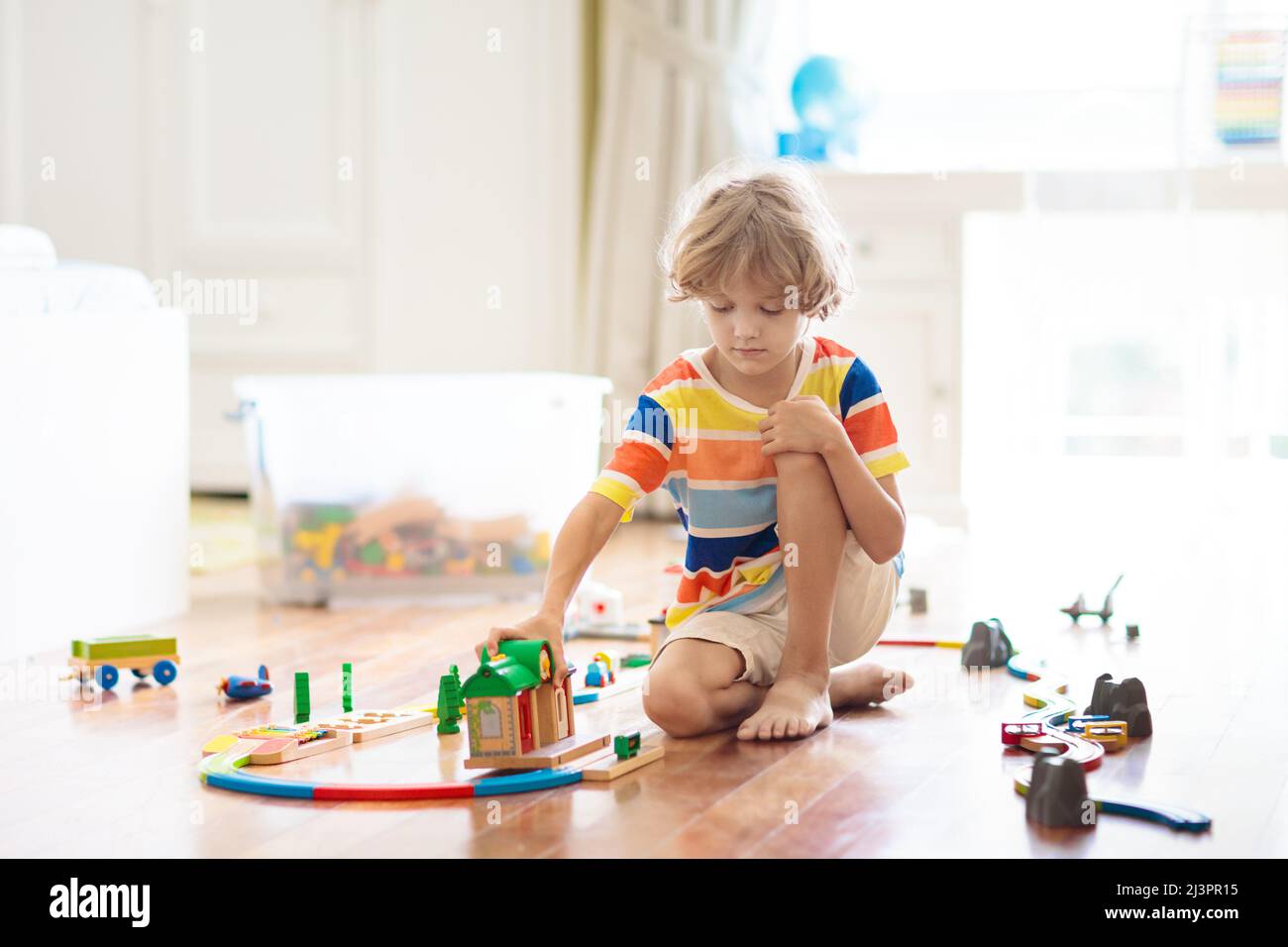 Kids play with wooden railway. Child with toy train. Educational toys