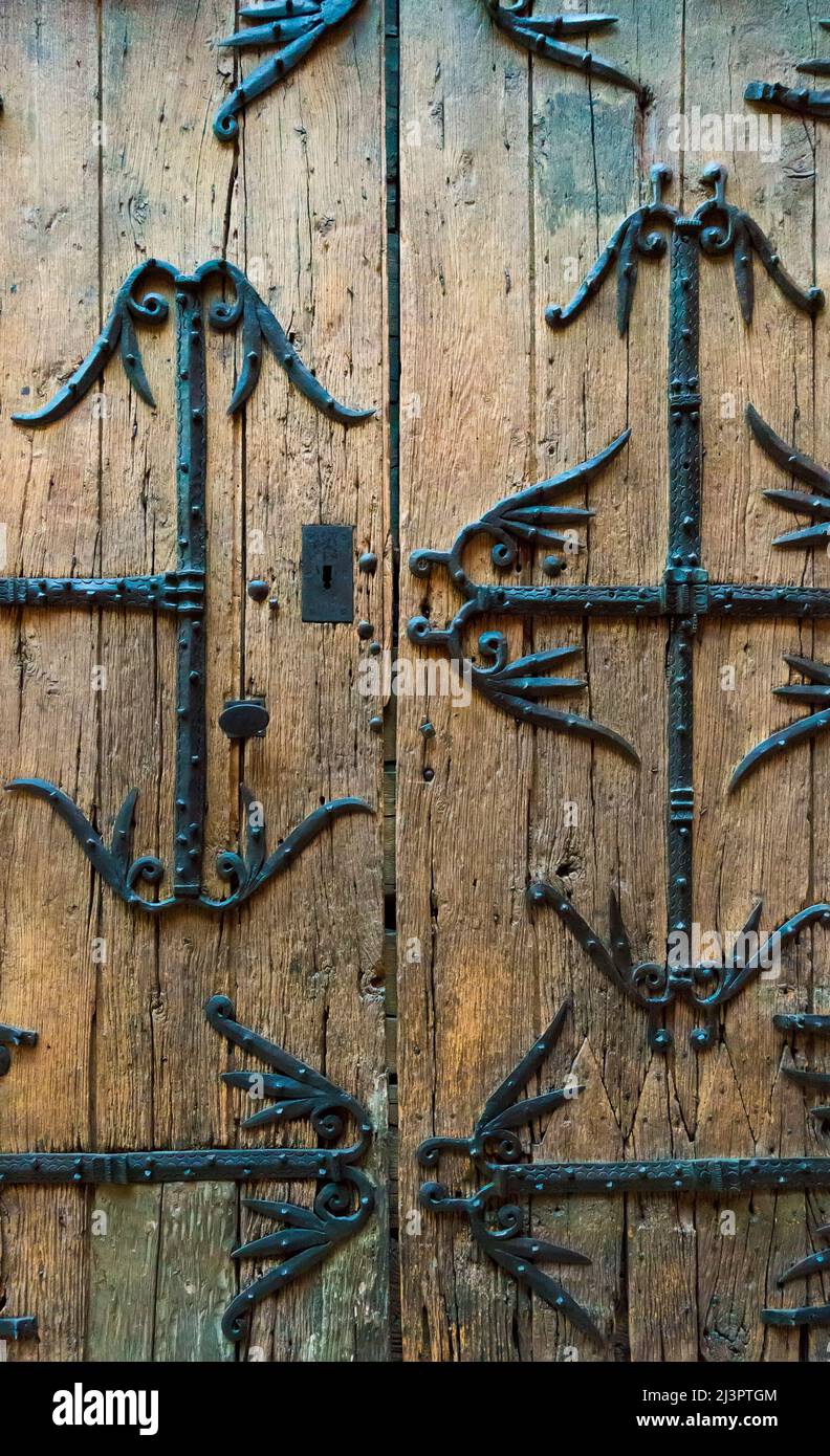 Old wooden door with metal reinforcements Stock Photo