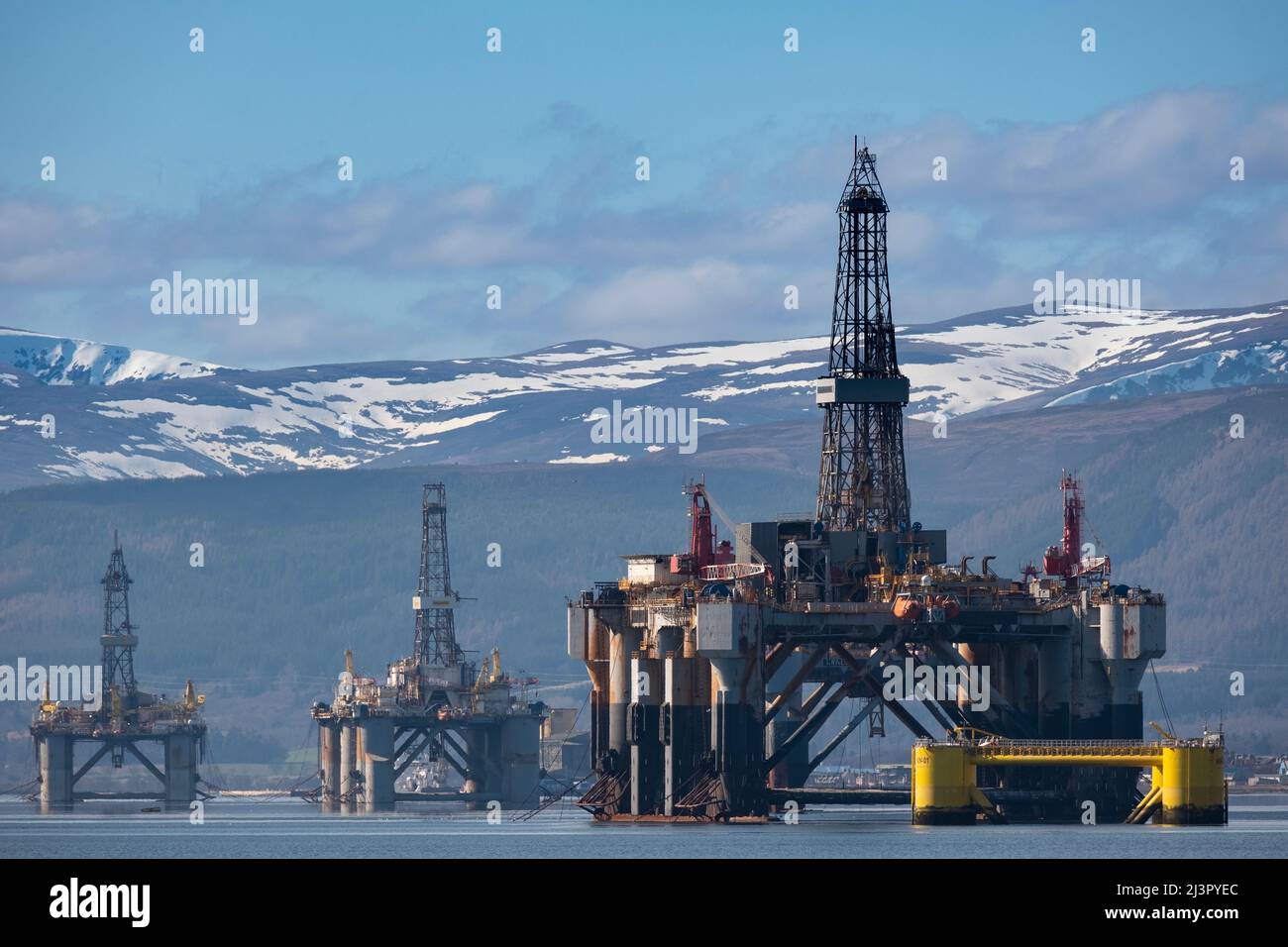I love the juxtaposition in this composition, the towering structures of the drill rigs brought into the Cromarty Firth for decomissioning with the st Stock Photo