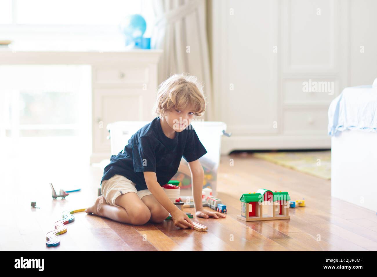 Kids play with wooden railway. Child with toy train. Educational toys
