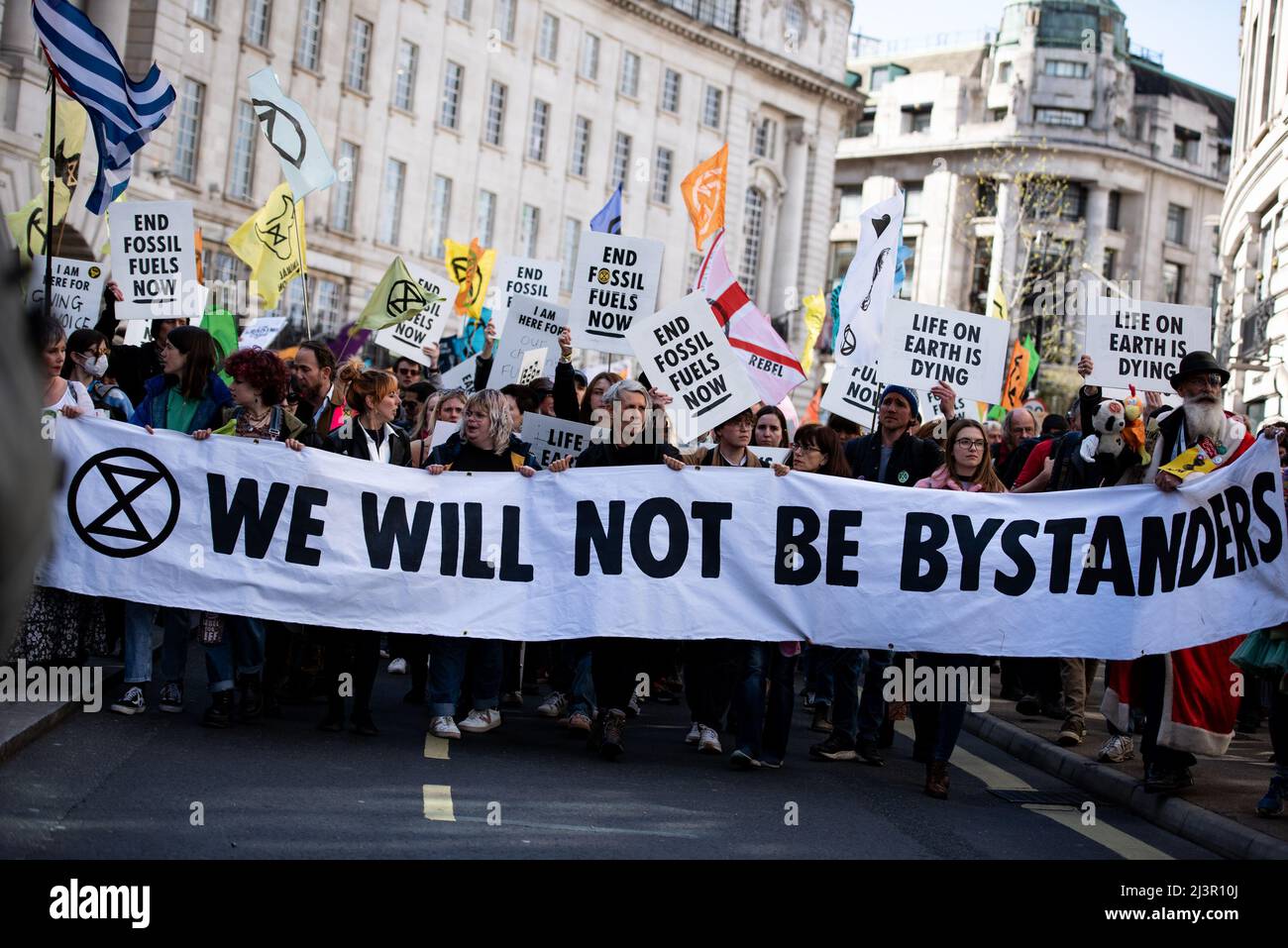 Protestors march with a large banner and placards during the